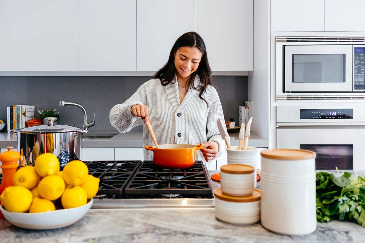 A beginner following cooking tutorials for beginners while chopping vegetables with proper knife grip